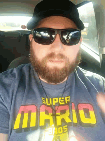 a man is wearing sunglasses and a super mario shirt