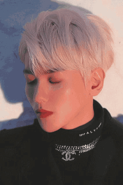 a close up of a man wearing a black turtleneck with the word ally on it