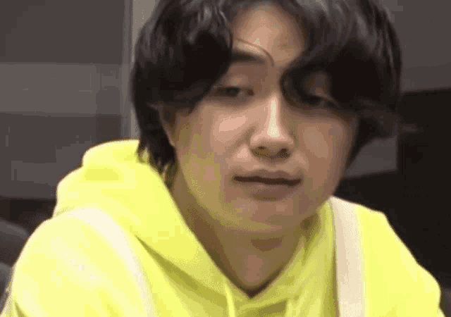 a close up of a person wearing a yellow hoodie
