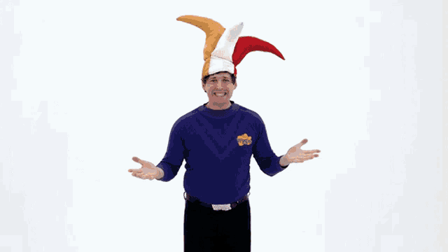 a man wearing a purple shirt with a yellow star on it is wearing a jester hat