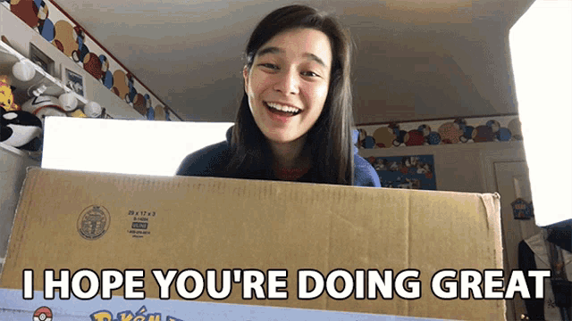 a woman holding a box that says i hope you 're doing great on it