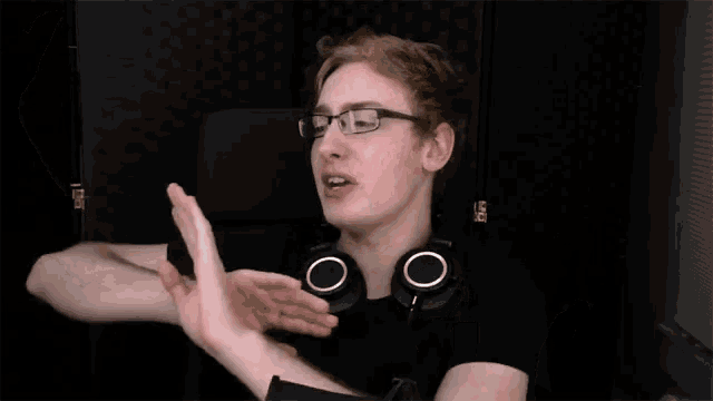 a man wearing glasses and headphones says no with his hands in the air