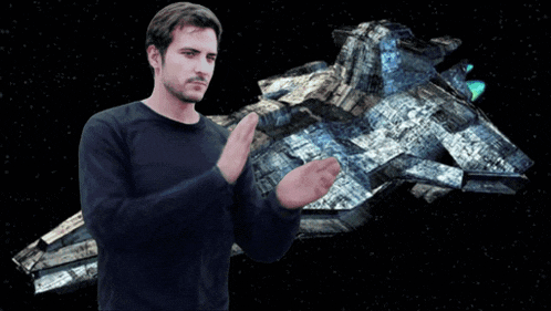 a man stands in front of a space ship with the word bravo written above him