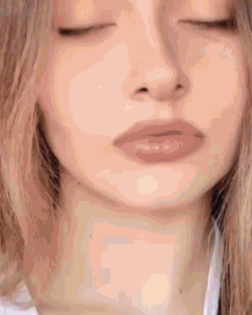 a close up of a woman 's face and neck with her eyes closed