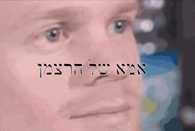 a close up of a man 's face with the words in hebrew above it