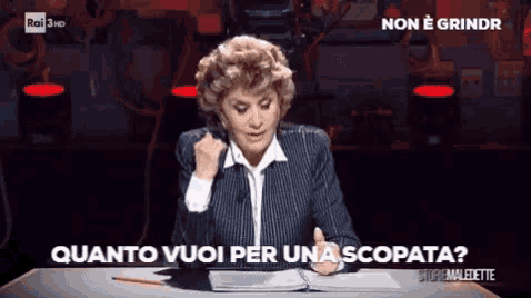 a woman sitting at a desk with the words " quanto vuoi per una scopata " written above her
