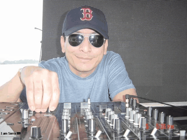 a man wearing a boston red sox hat is playing music