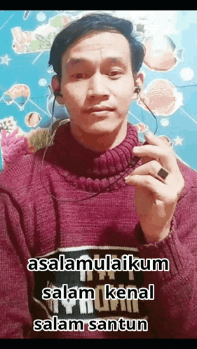 a man wearing ear buds and a sweater says " assalamualaikum "