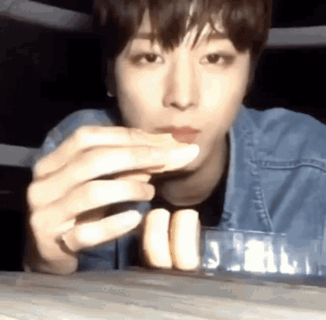 a young man in a denim jacket is eating a banana .