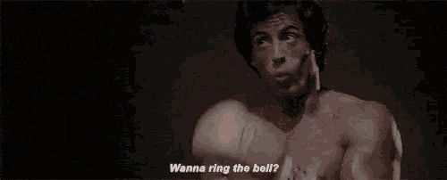 rocky balboa is wearing boxing gloves and saying `` wanna ring the bell '' .