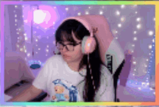 a girl wearing pink headphones and glasses is sitting in a chair .