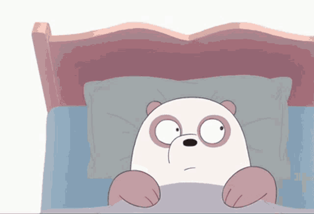 a panda bear laying in a bed with a pillow