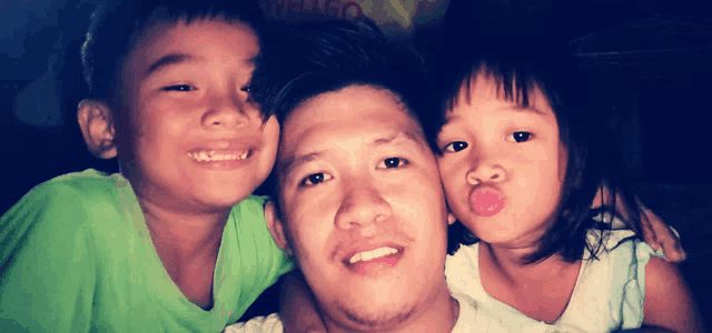 a man and two children are posing for a picture and one of the children is sticking her tongue out at the camera