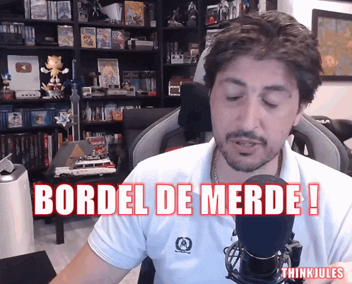 a man in front of a microphone with the words bordel de merde written above him