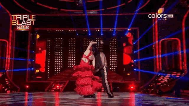 a man and a woman are dancing on a stage with the words triple blast in the corner