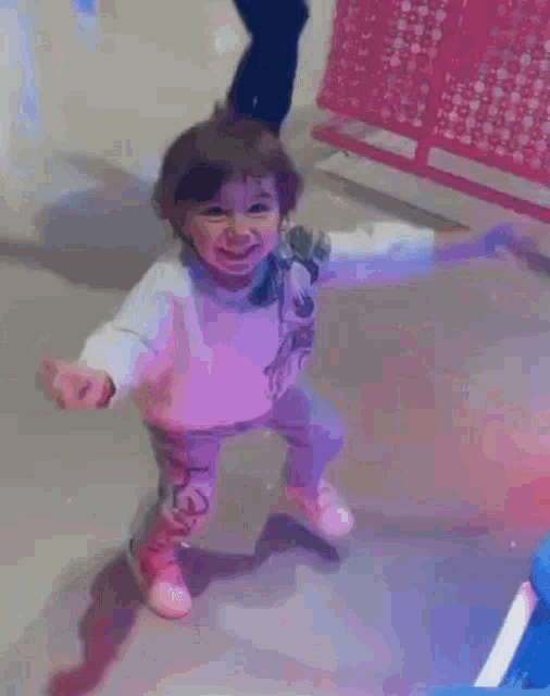 a little girl in a white sweater is standing next to a man in a blue shirt .