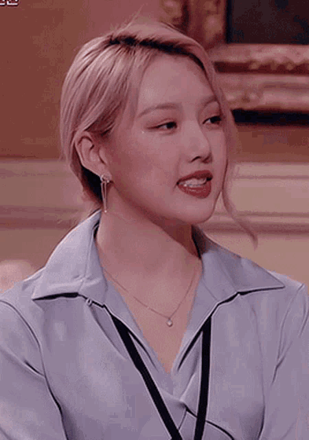 a close up of a woman wearing a blue shirt and a lanyard .