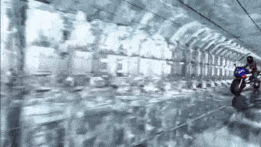 a person riding a motorcycle in a tunnel with a reflection