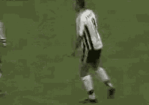 a group of soccer players are standing on a field and talking to each other .