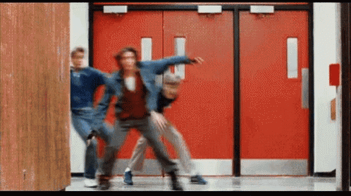 a group of people dancing in front of red doors
