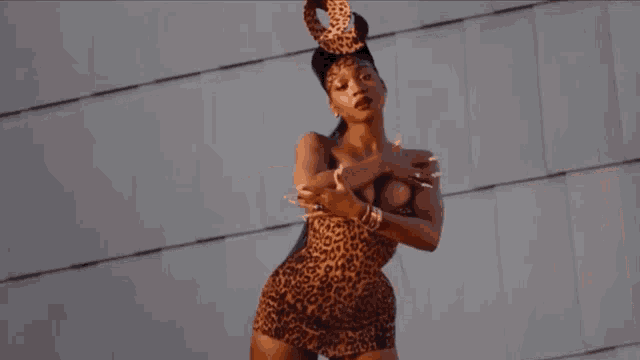 a woman in a leopard print dress stands in front of a building