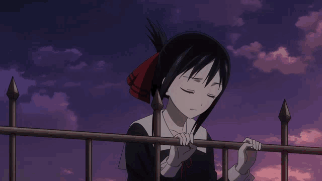 a girl with black hair and a red ribbon in her hair is leaning on a fence