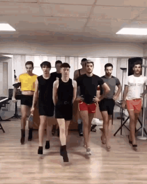 a group of men are dancing in a room and one of the men is wearing a shirt that says ' stefan '