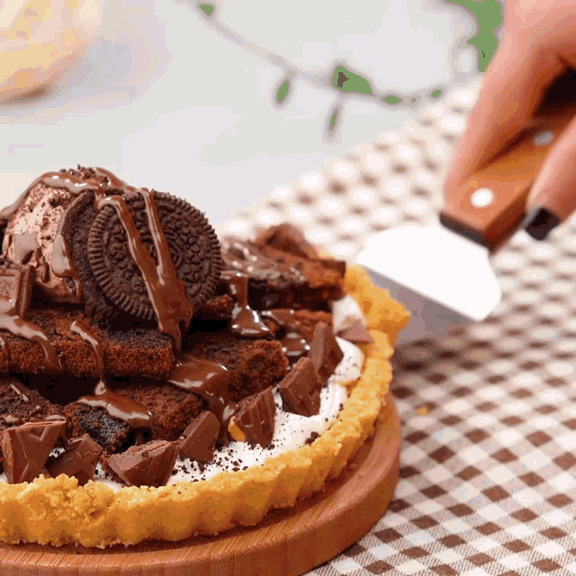 a person is cutting a cake with oreos and chocolate