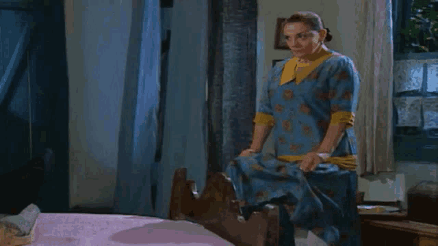 a woman in a blue dress is standing in a room