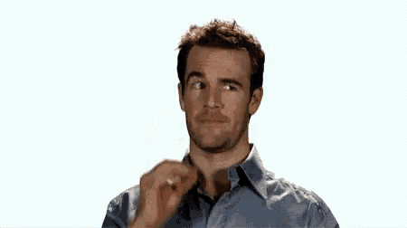 a man in a blue shirt is eating a piece of chicken .
