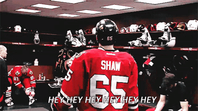 a hockey player named shaw is standing in the locker room