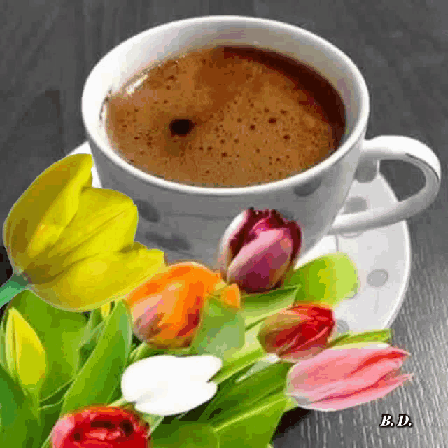 a cup of coffee is sitting on a saucer next to flowers .