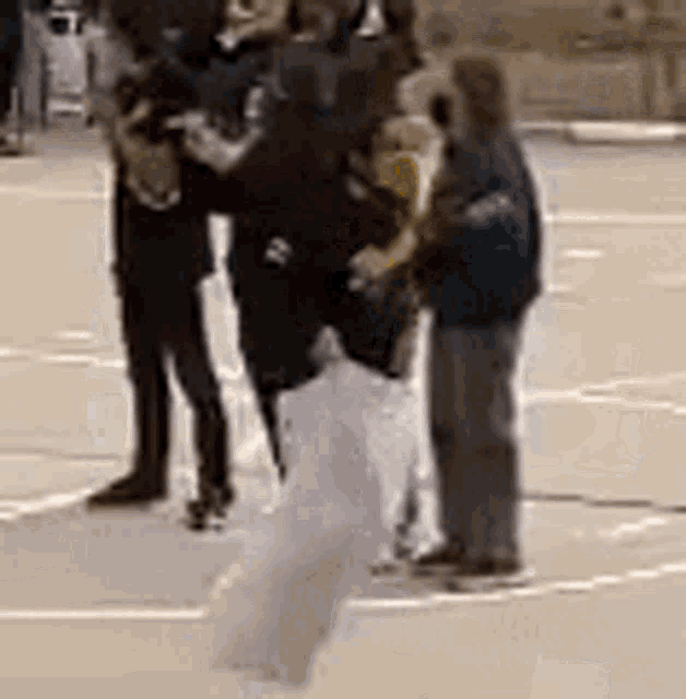 a group of people are standing on a court .