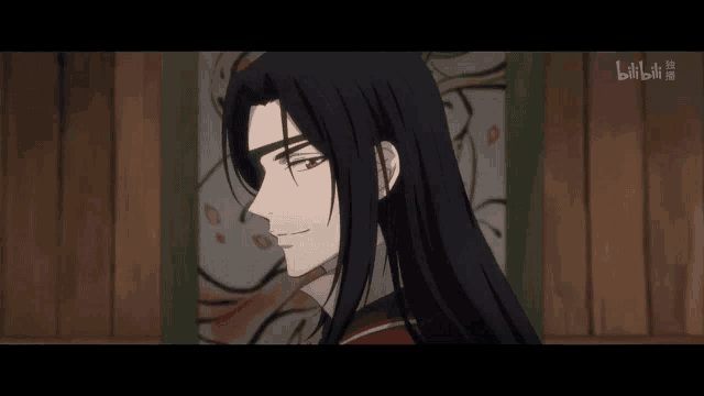 a man with long hair and a bandage on his eye looks at the camera
