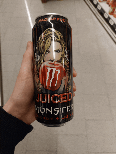 a person holding a can of juiced monster