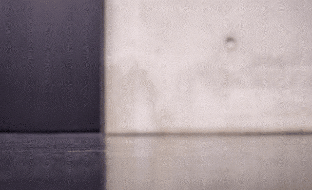 a blurred image of a wall with a black corner
