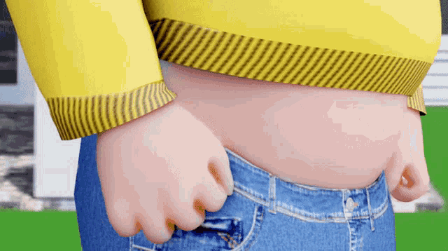 a person wearing a yellow sweater and blue jeans