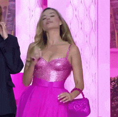 a woman in a pink dress holds a purple purse