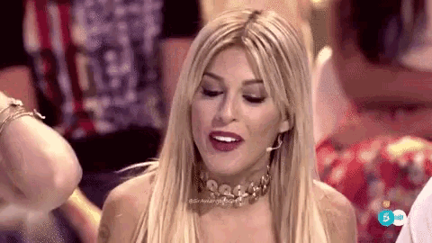 a woman wearing a choker and earrings is sitting in a crowd of people .