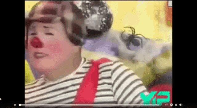 a video of a clown wearing a red nose and a hat .