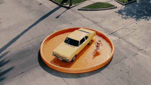 a woman in a red and white dress is laying in a chair in front of a yellow car