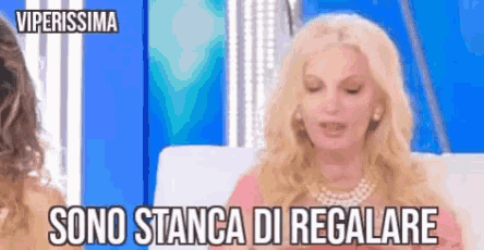 a woman is sitting on a couch with her eyes closed and the words sono stanza di regalare written above her .
