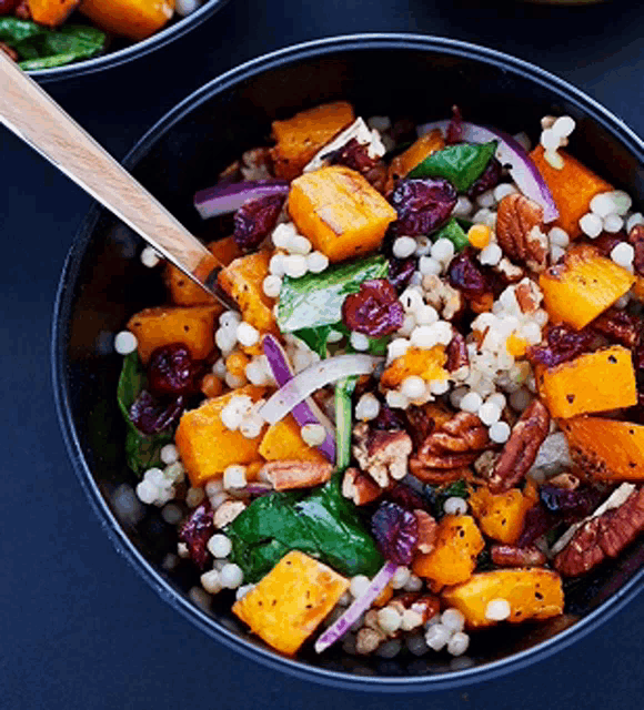 a bowl of food with a wooden spoon in it on a table