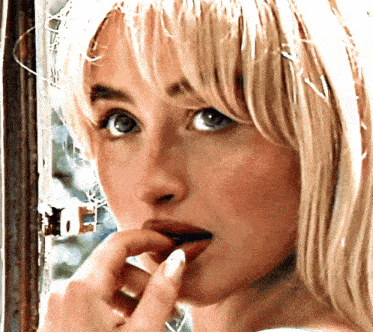a close up of a woman applying lipstick
