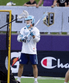 a lacrosse player is standing in front of a champion banner