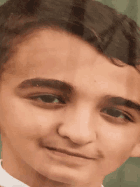 a close up of a young man 's face with a smile on his face .