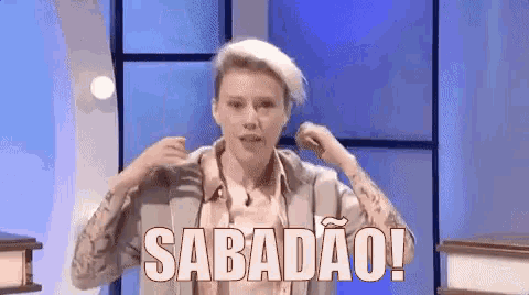 a man is standing in front of a blue wall with the word sabadao written on it