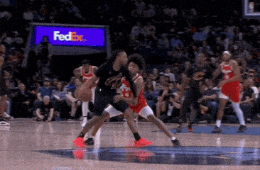 a basketball game is being played in front of a fedex sign .