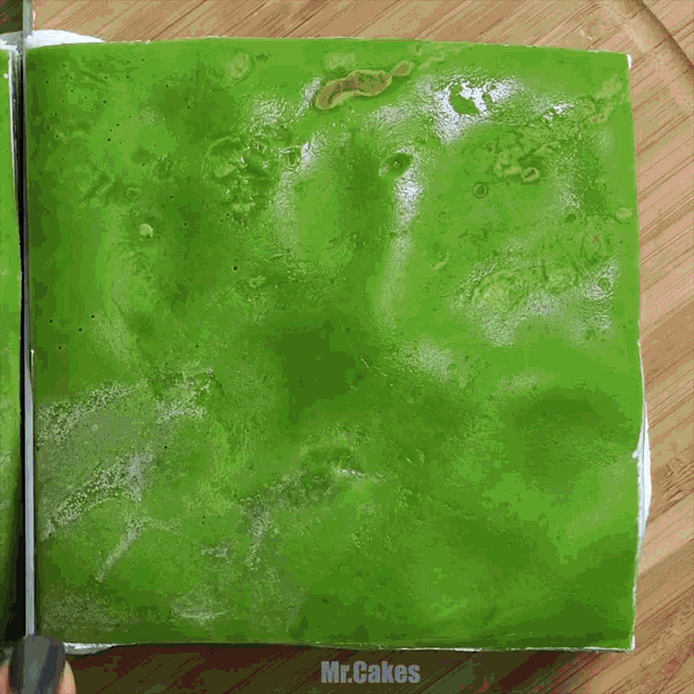 a slice of green and white cake on a wooden plate