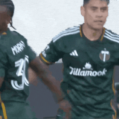 a soccer player wearing a green jersey that says tillamook